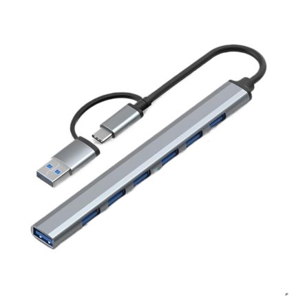Un hub USB-C a USB con siete puertos USB 3.0 y cuerpo de aluminio gris muestra su cable corto y conectores para ampliar la conexión del equipo.