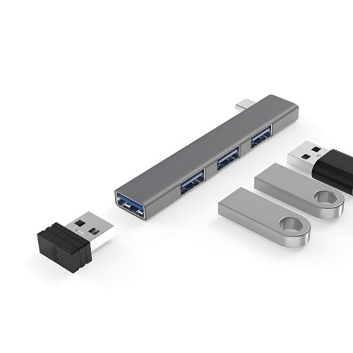 Un hub USB-C gris de aluminio del modelo EON con cuatro puertos USB y conectores USB-A visibles junto a adaptadores metálicos sobre fondo blanco.