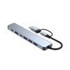 Un hub EON gris de aluminio con cable USB-C y USB, cuatro puertos USB-A azules, dos puertos USB-C y luz indicadora sobre fondo blanco limpio.