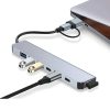 Un hub USB-C gris de aluminio conecta un portátil y muestra puertos USB-A, USB-C y cable corto con diseño compacto para ampliar la conectividad.