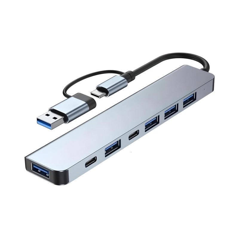 Un hub gris de aluminio con cable USB-C y USB-A, siete puertos entre USB y USB-C, en diseño compacto y alargado sobre fondo blanco.
