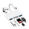 Un hub 6 en 1 blanco con conector USB-C, dos puertos USB-A, ranuras SD y microSD, junto a una memoria USB y tarjetas de memoria.