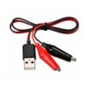 Un cable USB a pinzas cocodrilo de 58 cm muestra conectores rojo y negro junto a un enchufe USB, listo para pruebas eléctricas y alimentación DC.