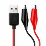 Un cable USB a pinzas cocodrilo muestra conectores rojo y negro junto a un conector USB tipo A, pensado para pruebas eléctricas y alimentación DC.