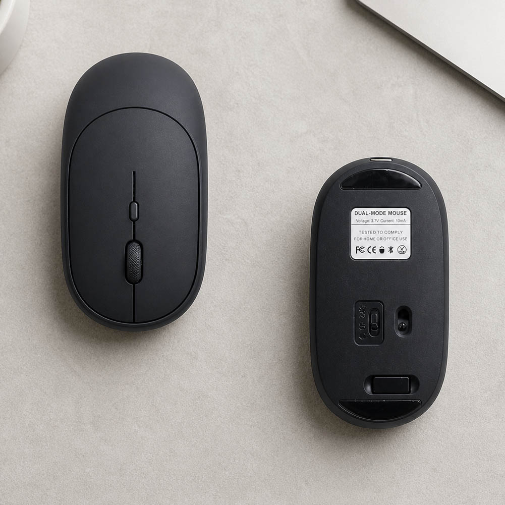 Dos vistas de un mouse inalámbrico negro slim muestran su diseño compacto, el botón central, el interruptor dual y la base con sensor y selector.