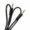 Un cable auxiliar negro de 3,5 mm macho a macho con conectores dorados conecta dispositivos portátiles y equipos de audio compatibles.